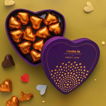 Heart-shaped dark chocolates in a golden-wrapped box